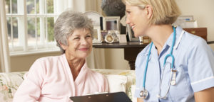 Retired Senior Woman Having Health Check With Nurse At Home