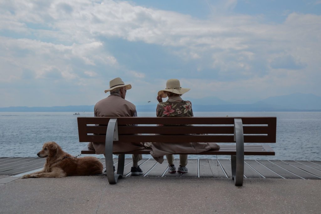 What is hospice care? Learn more in this article, highlighted by this image of a man and woman on a bench with a dog.