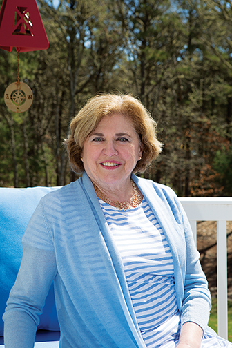 A photo of an older white woman sitting outdoors looking straight at camera