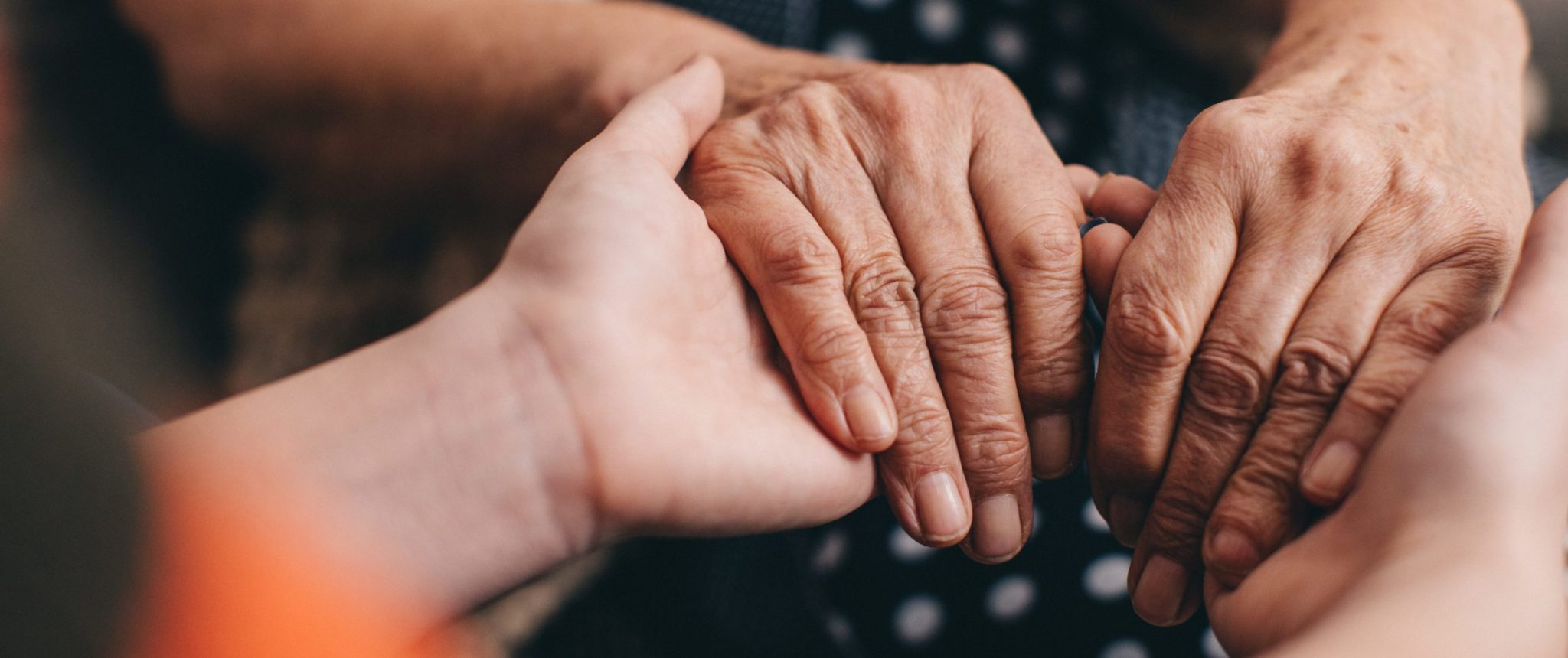 Grandmother and granddaughter holding hands - you only see a close of up their hands