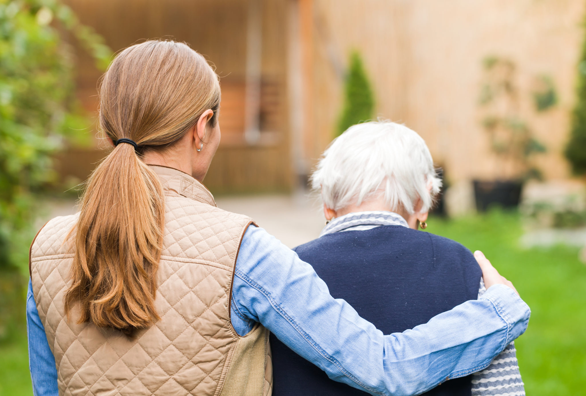 Elderly care Young carer walking with the elderly woman in the park