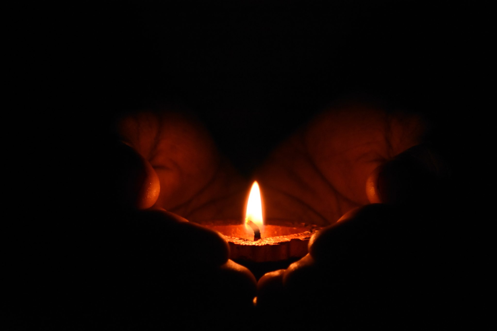 adult-blur-burn-783200 hands holding candle