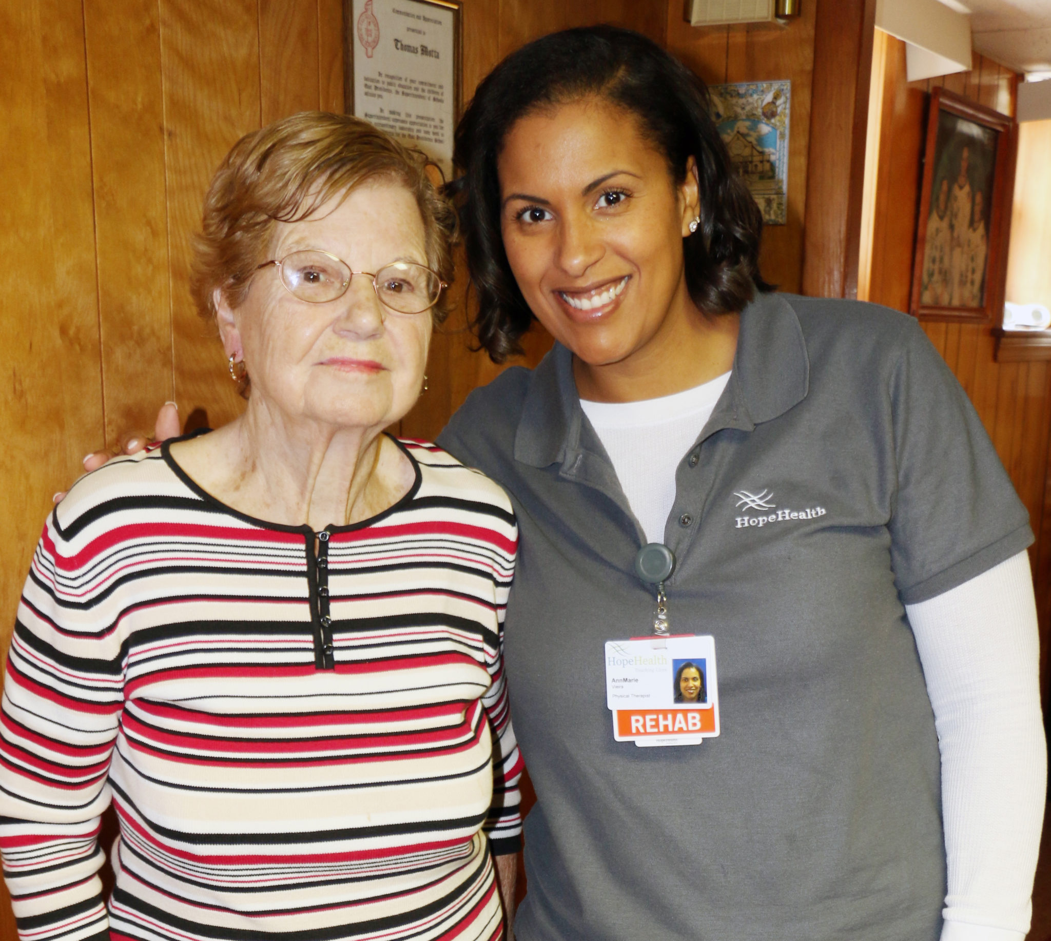 Physical therapist stands with female patient