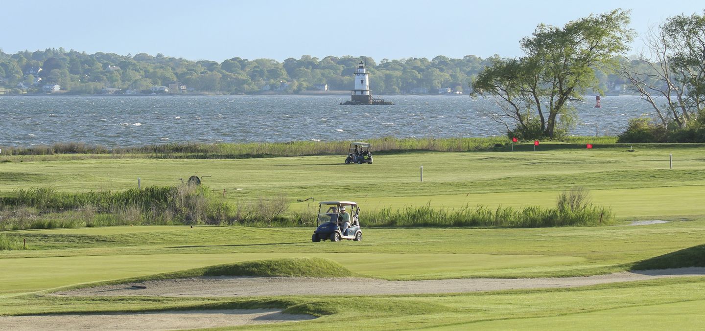 golf course with ocean in the background and a lighthouse