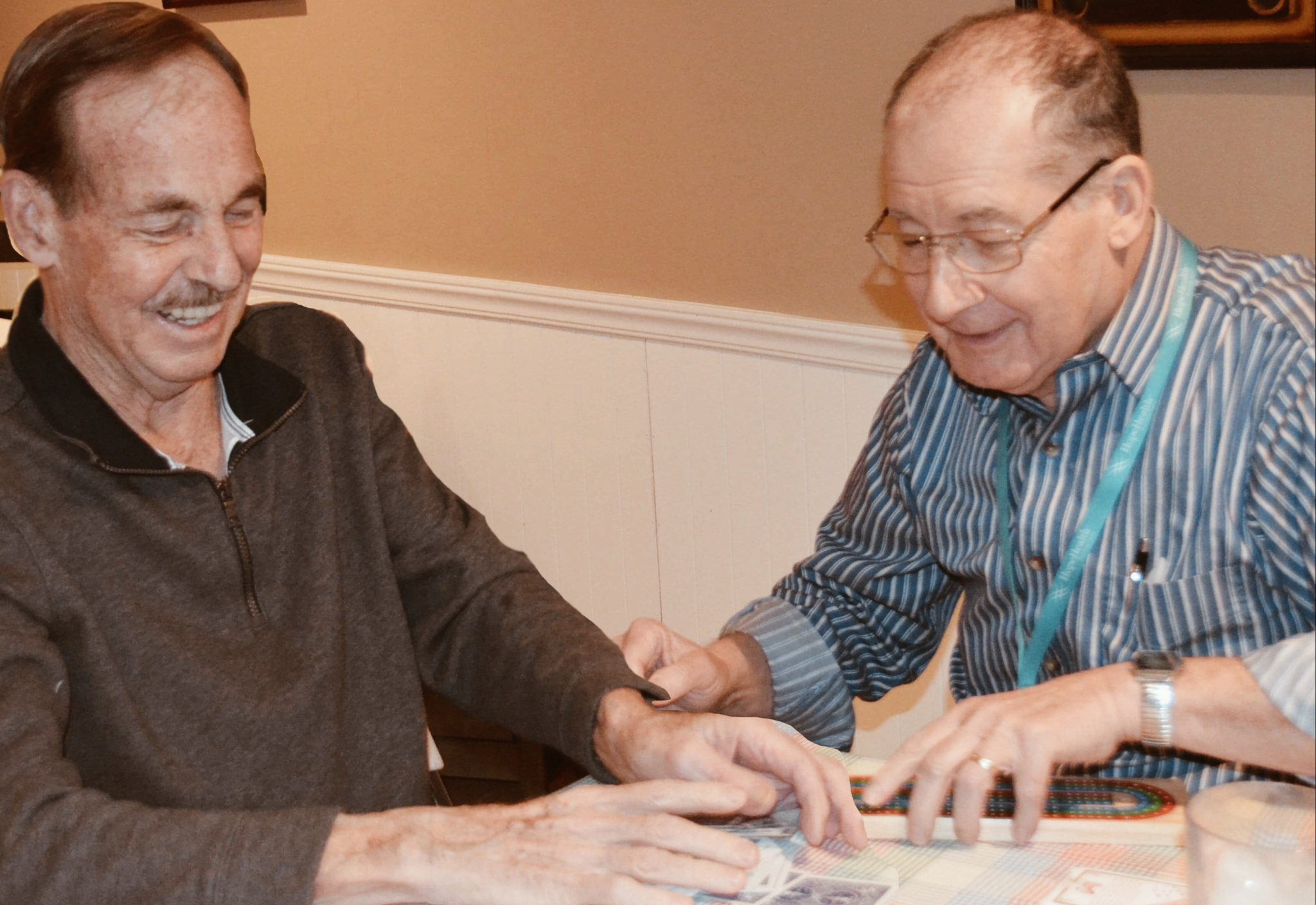 two men playing cards at table