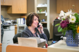 administrative volunteer woman answering phone with flowers in the foreground