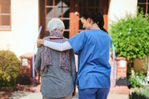 Rearview shot of a senior woman and a nurse going for a walk together in a retirement home garden