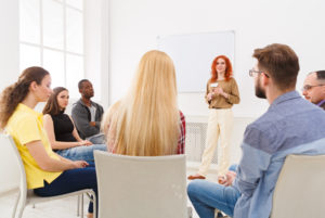 Community volunteer Rhode Island and Massachusetts Redhead woman doing presentation in office, copy space. Startup business meeting, sharing new ideas to partners, teamwork concept