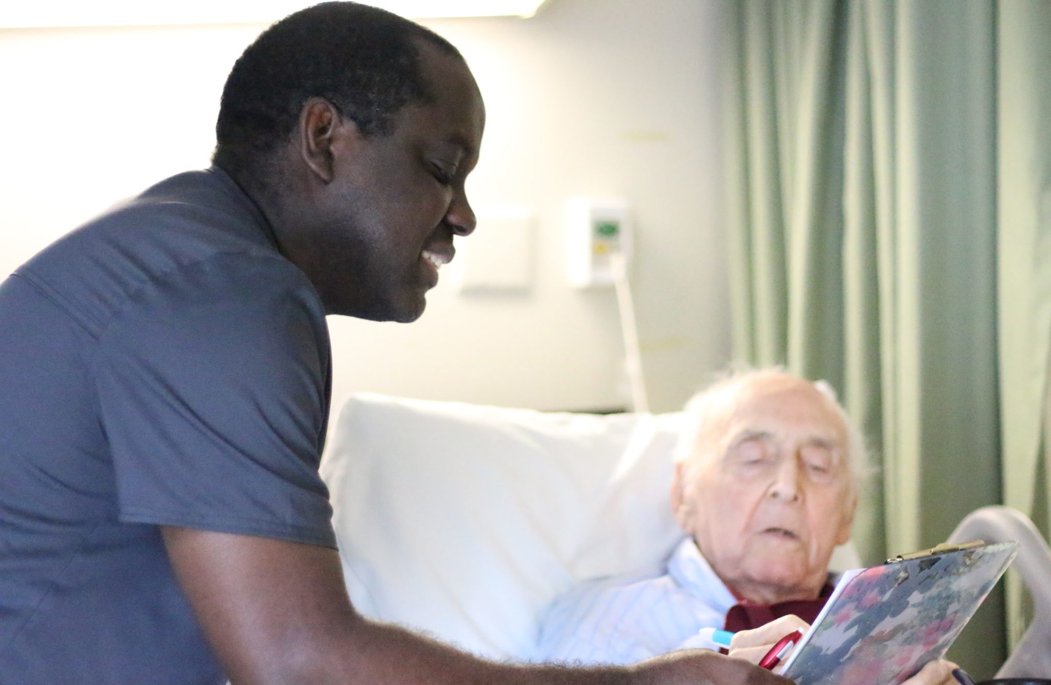 Man helping elderly patient read