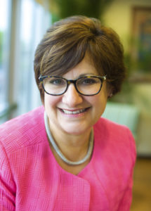 Diana Franchitto 5500_digital file Woman in pink blazer and glasses smiling in a well-lit room