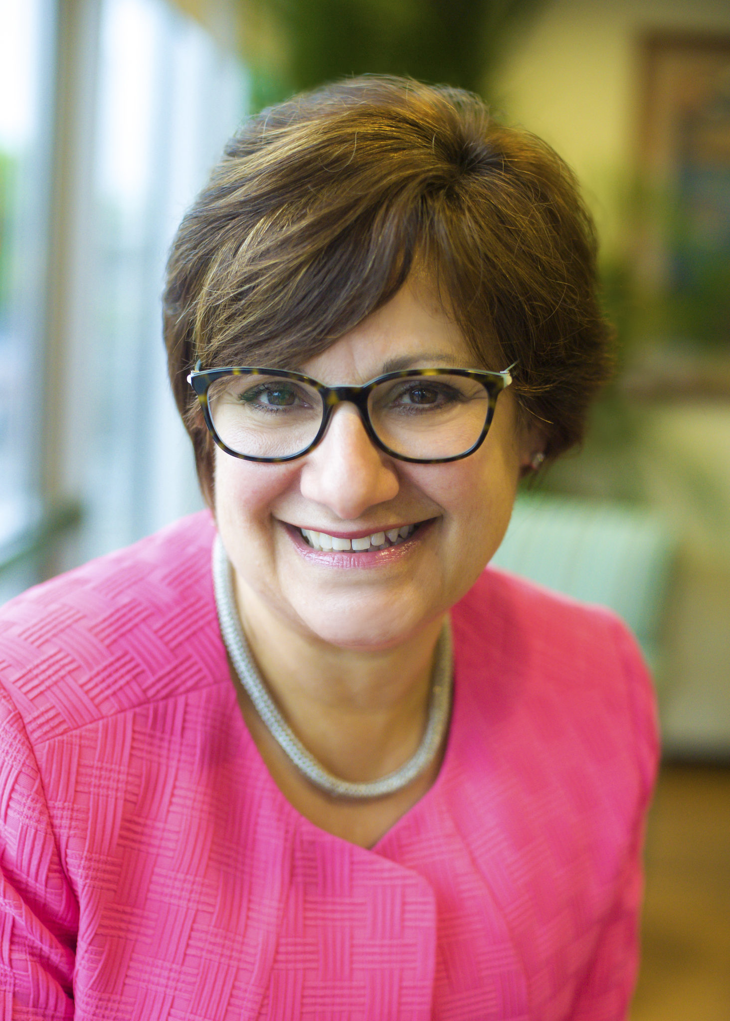 Diana Franchitto 5500_digital file Woman in pink blazer and glasses smiling in a well-lit room