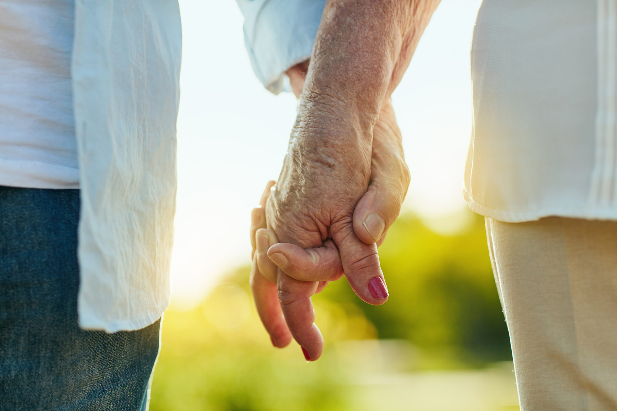 Cropped shot of a senior couple holding hands in a park
