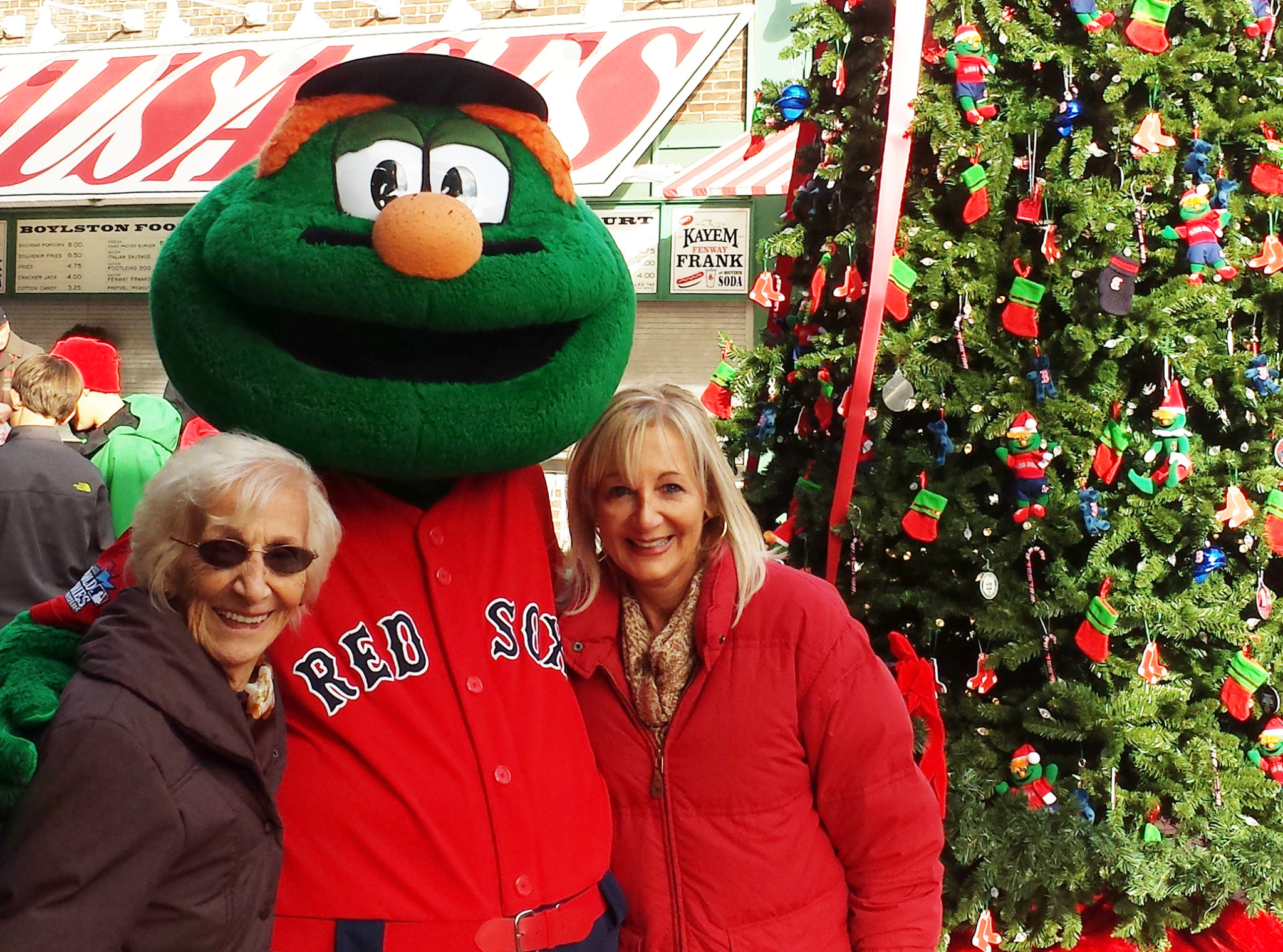 Mom and elderly mom with the Red Sox mascot next to a Christmas tree