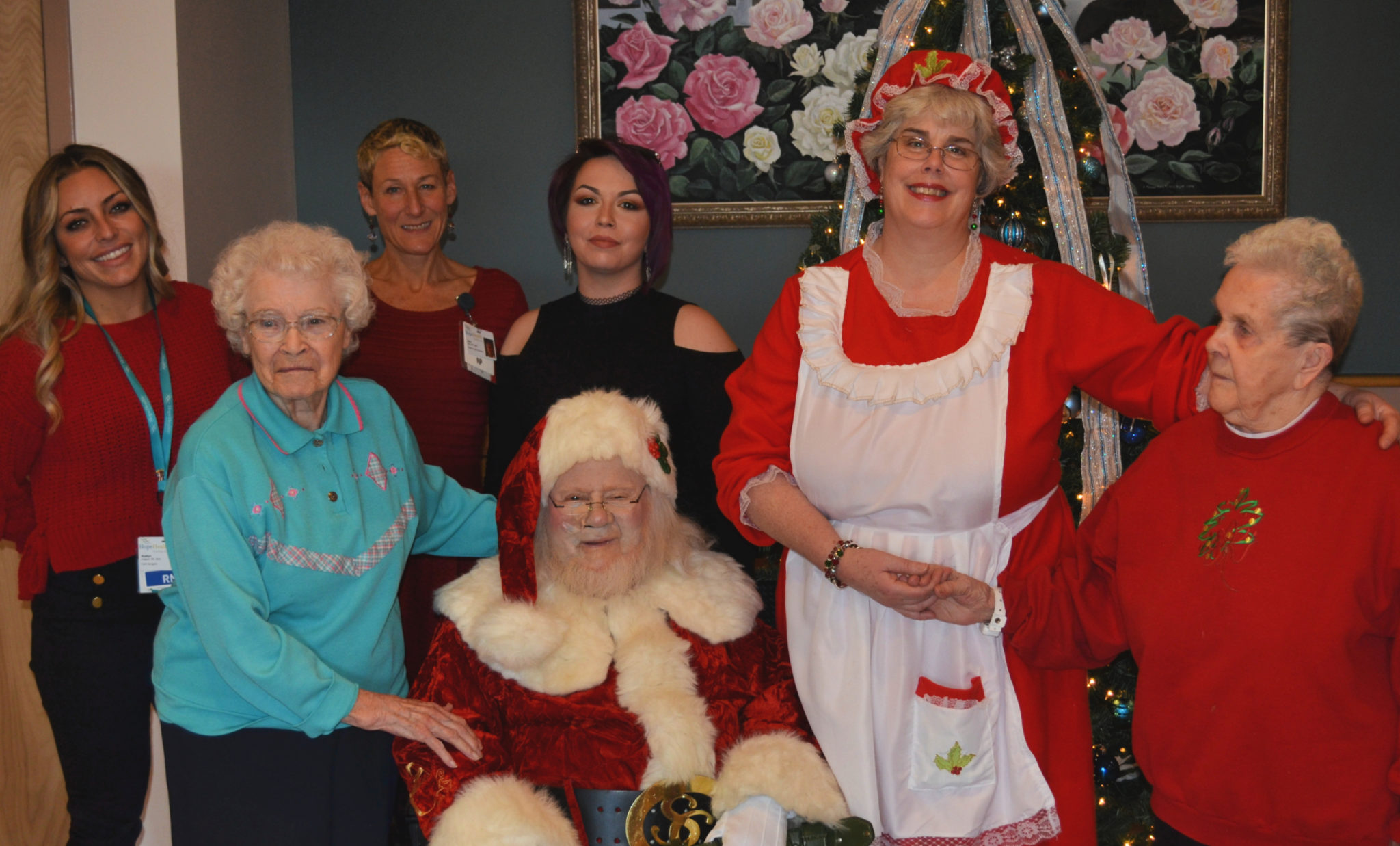 People surrounding a sitting Santa Claus