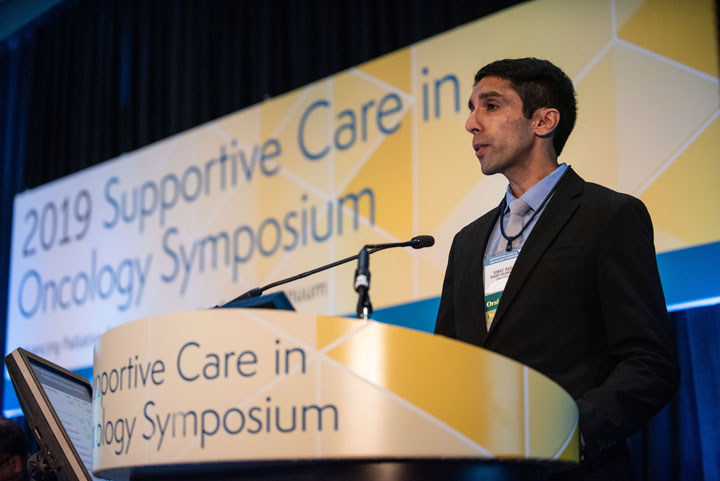 Man speaking at an oncology symposium