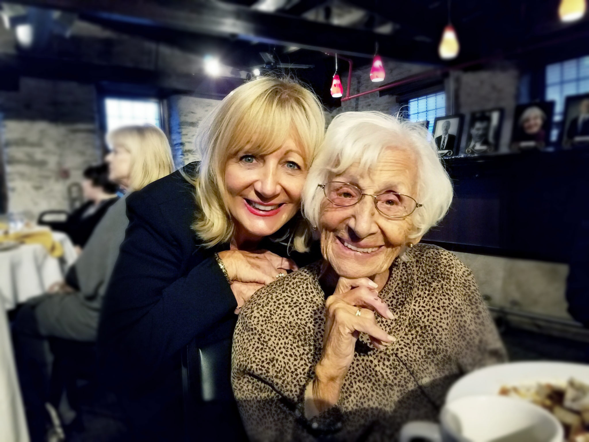 Daughter embracing her elderly mother at a restaurant