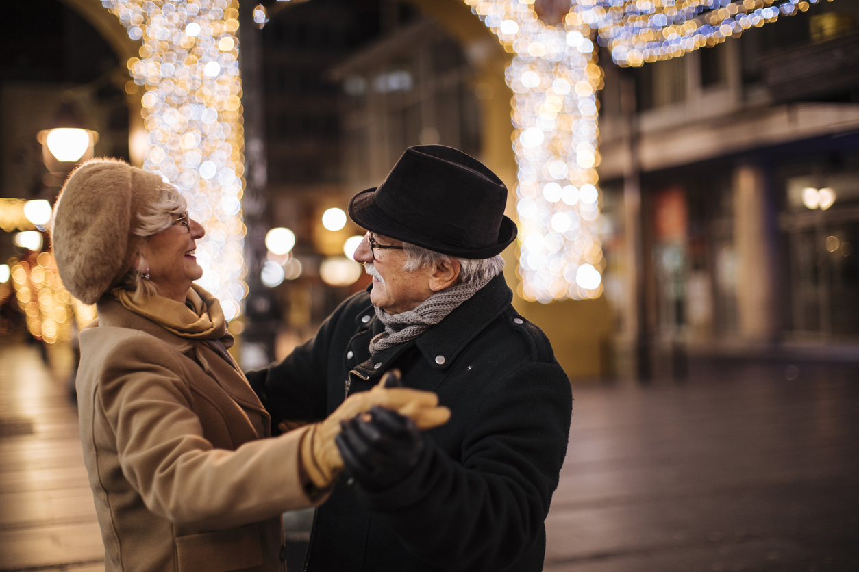 Grandma and grandpa enjoying winter holidays on the street dancing
