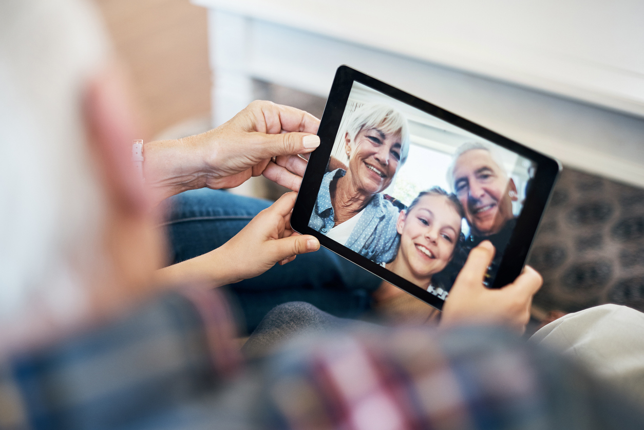 Shot of an adorable little girl using a digital tablet with her grandparents at home