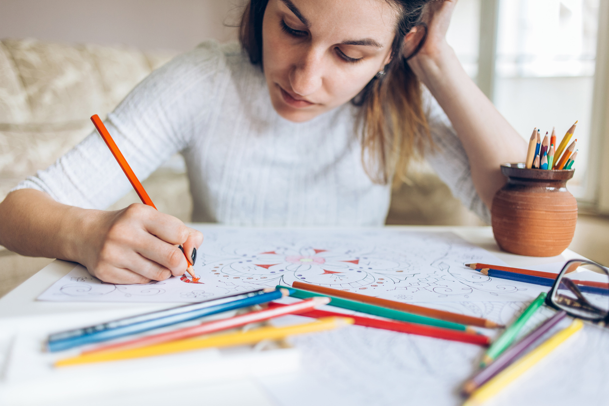 Youmg woman drawing with color pencils for relaxation.
