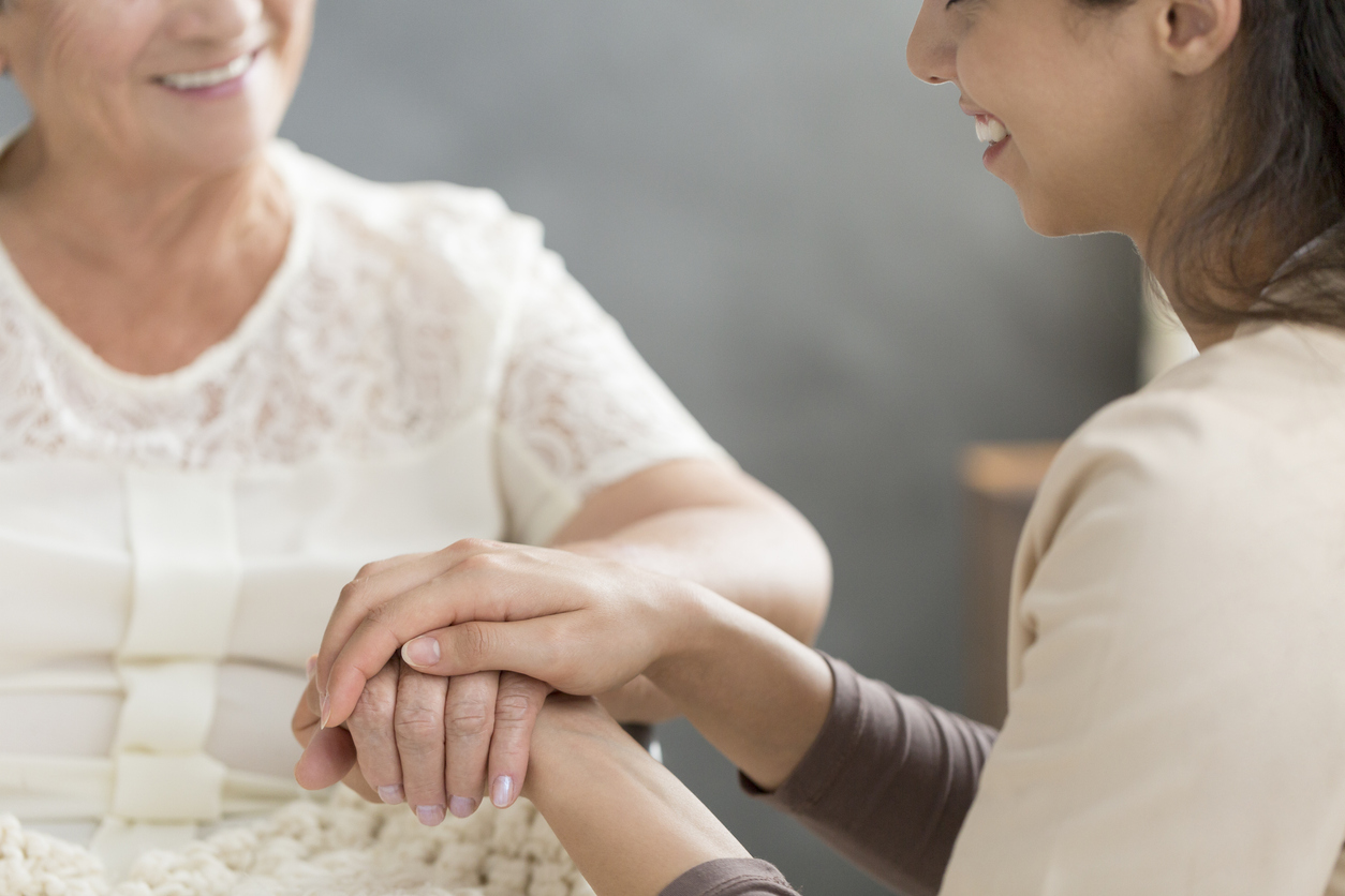 Close-up of volunteer's hand taking care of senior person