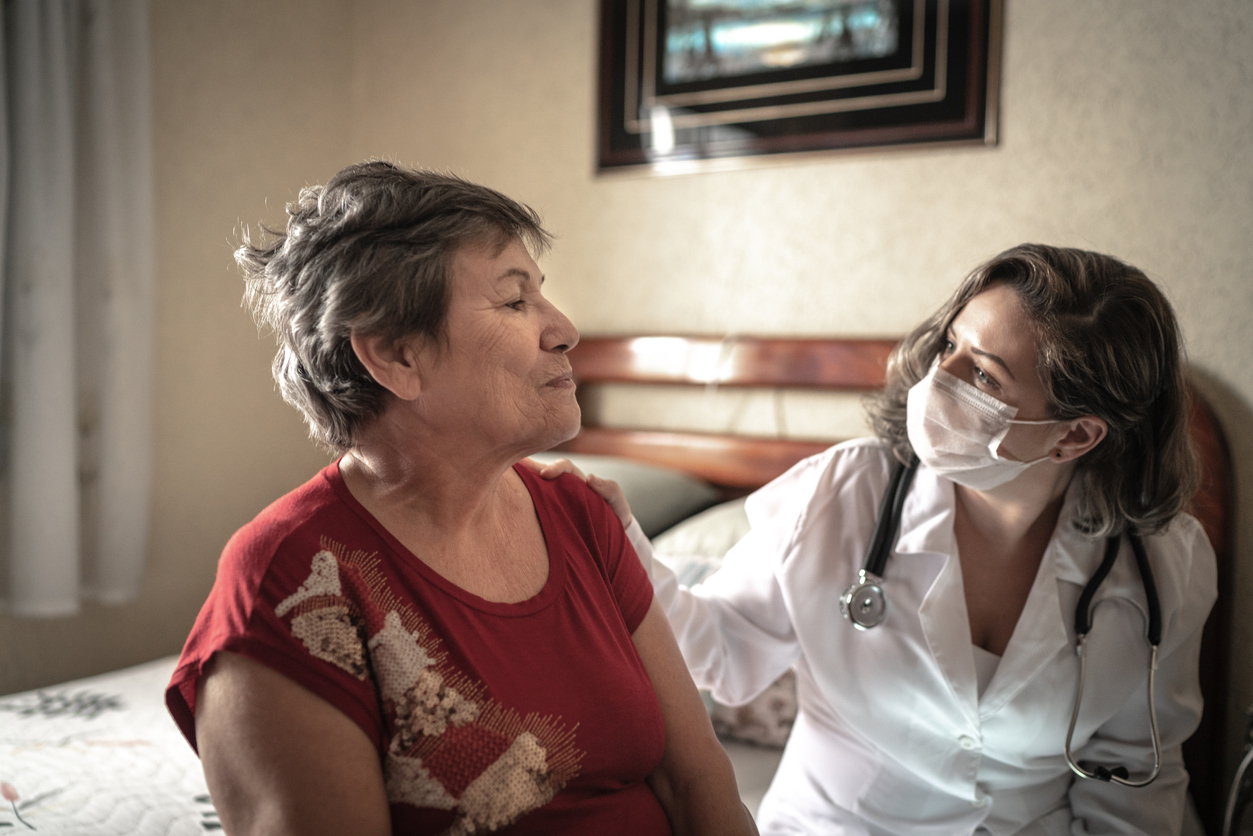 Health visitor talking to a senior woman during home visit