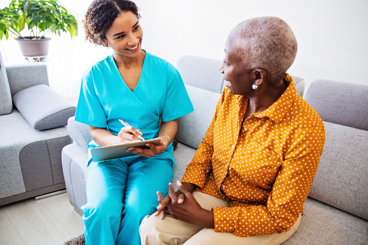Nurse Visiting a Senior Female Patient at Home nurse is attending to her senior female patient at home, facing her concerns and answering questions