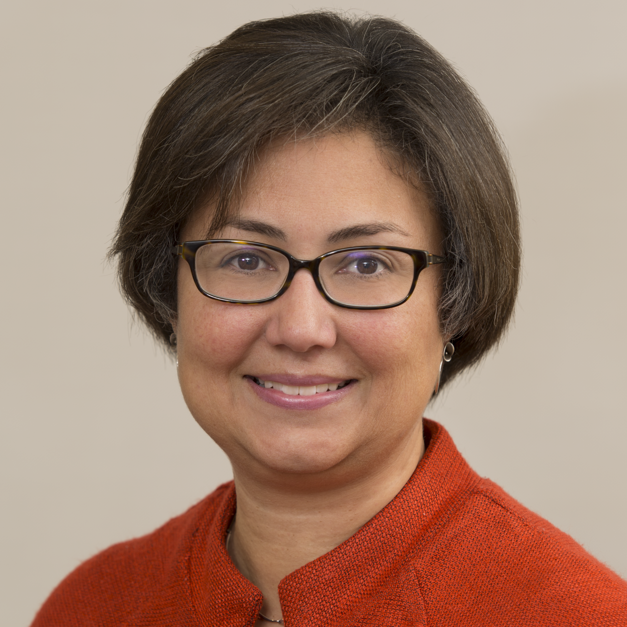 Professional woman in red jacket wearing glasses, human resources executive