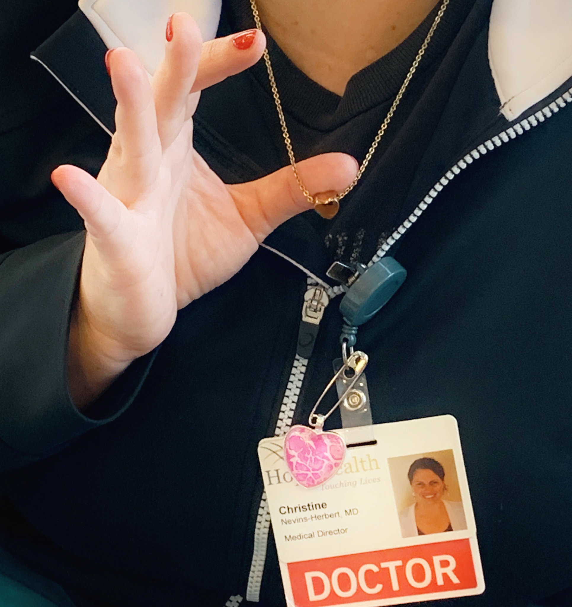 Woman with doctor badge shows off heart necklace