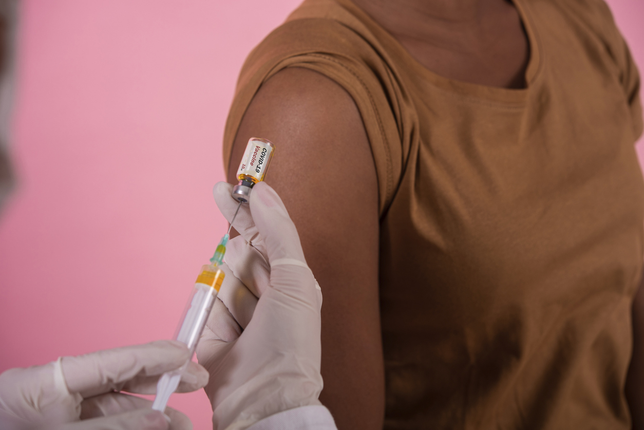 Unrecognizable African - American woman taking the Covid-19 vaccine.