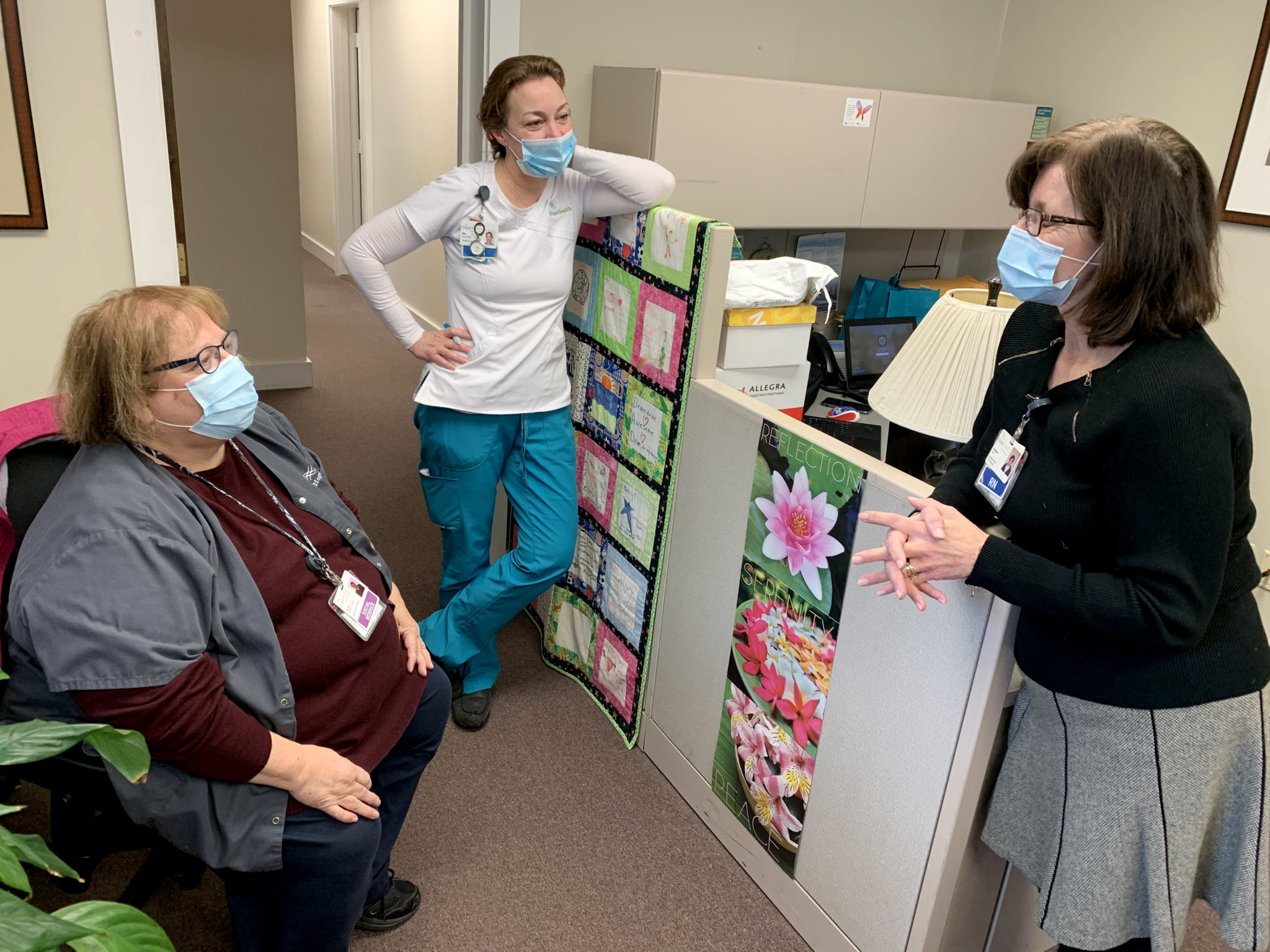 Hospice social worker chats with co-workers at office