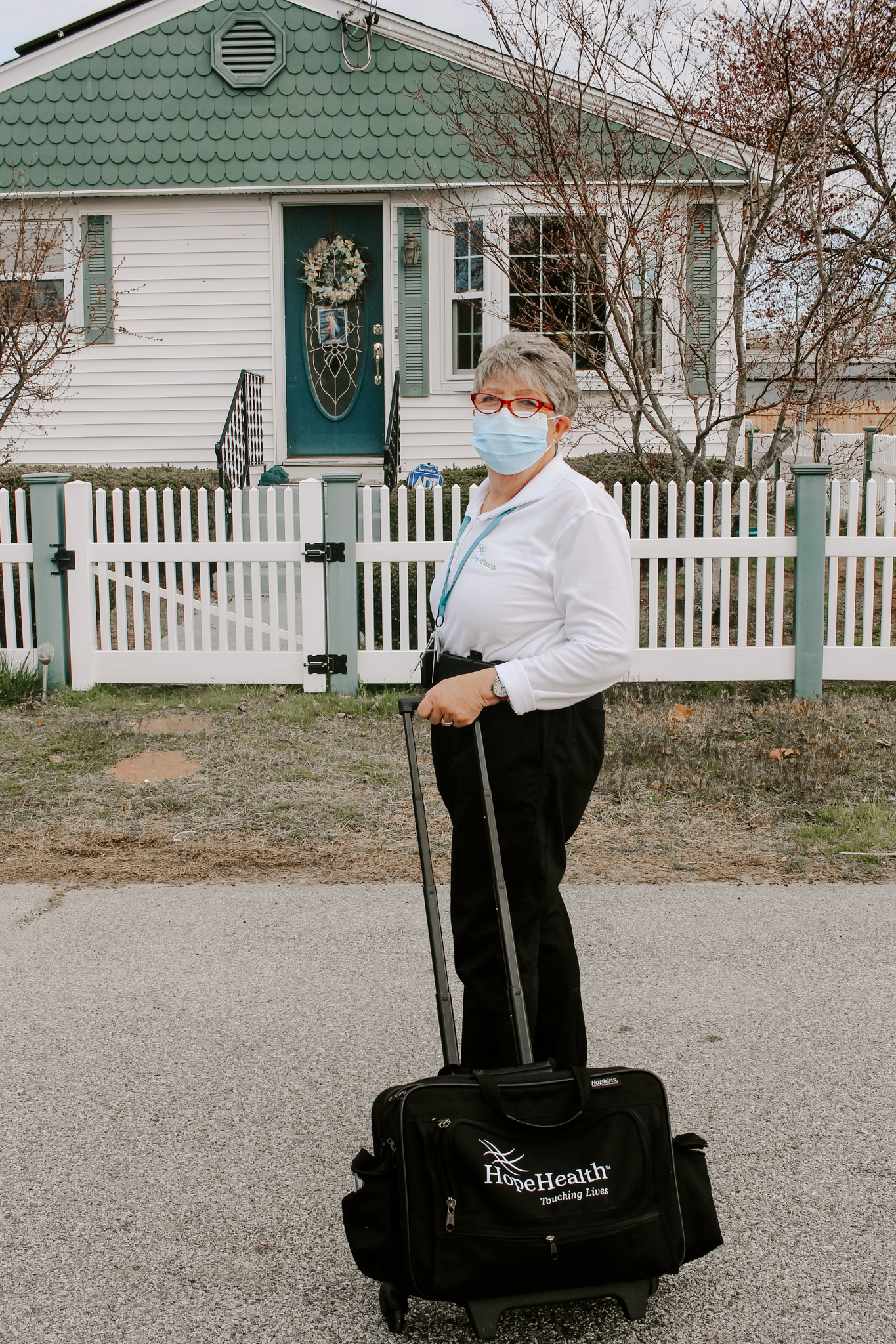 Home health care occupational therapist roles her bag of equipment into a patient's home to provide compassionate care