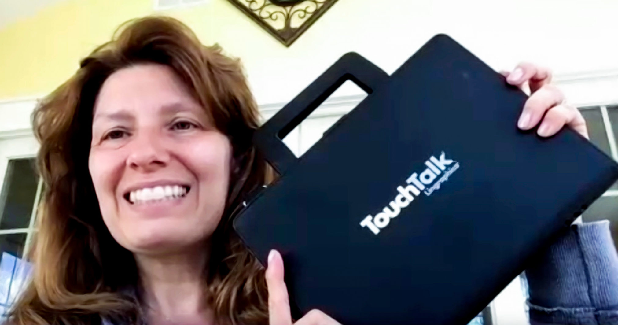 Female HopeHealth Speech Language Pathologist Joni Hodges holds up one of her favorite tools, an augmentative and alternative communication device from Lingraphica. The tablet makes it easy for people with a wide range of abilities to communicate in several ways.