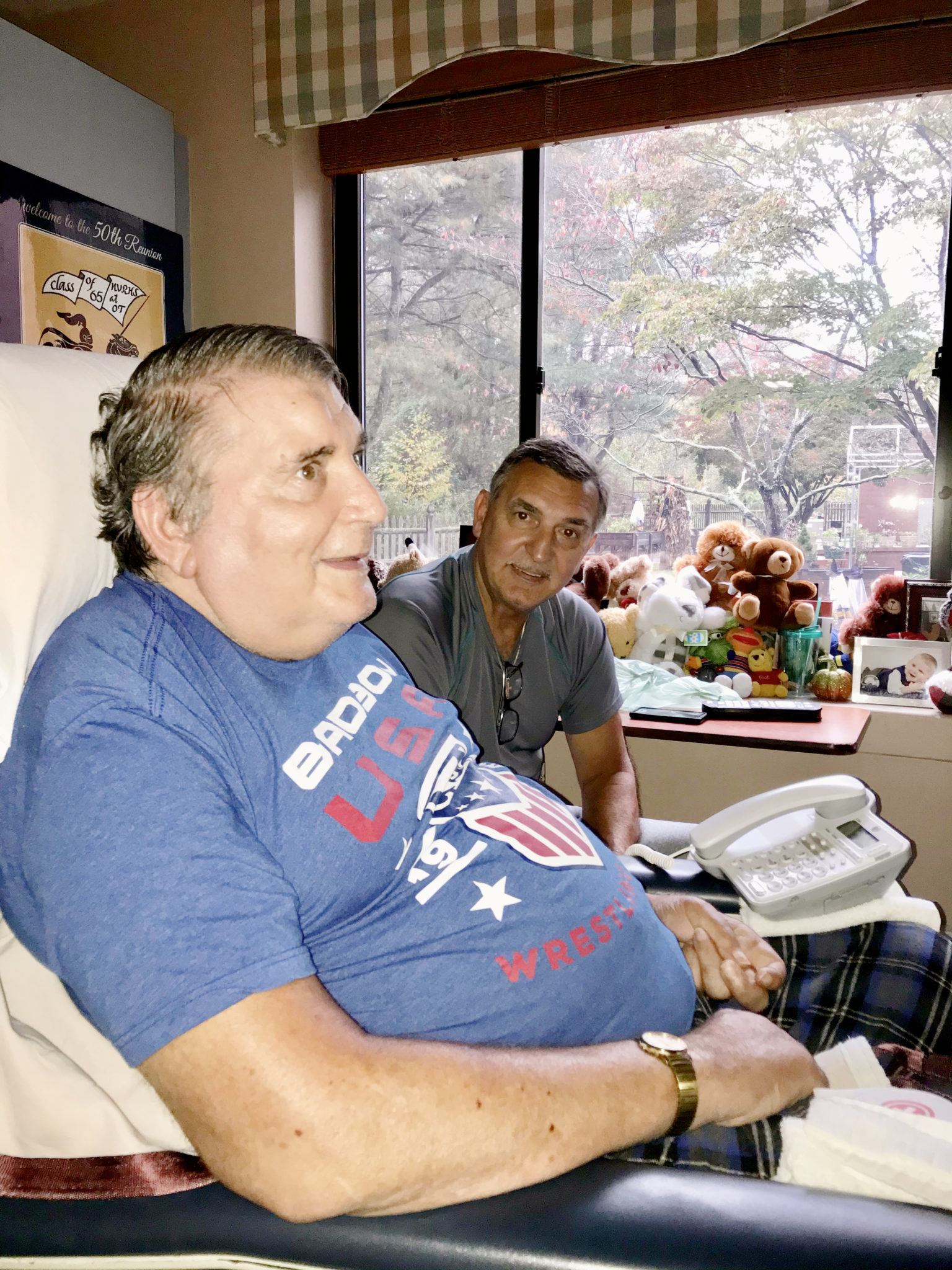 Two men smiling in a room filled with stuffed animals