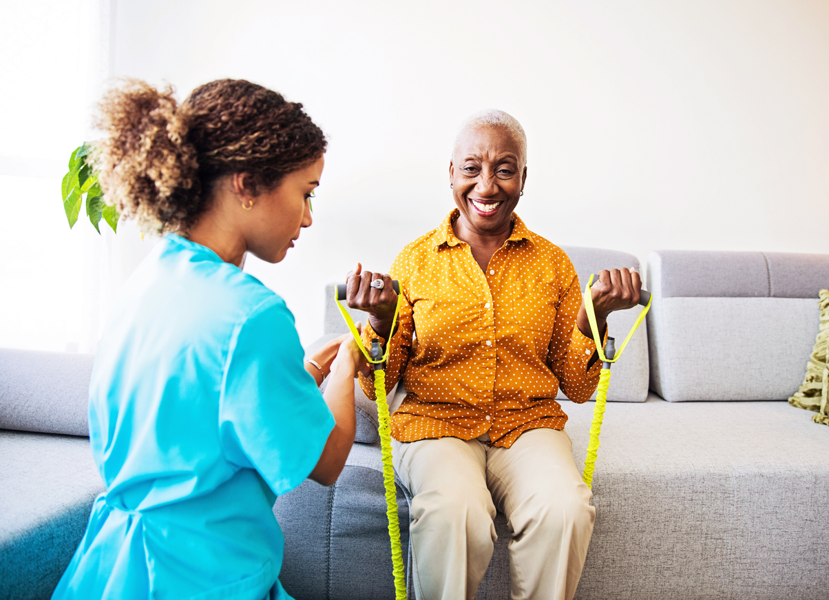 Home Visit - Nurse and her Patient Nurse home visiting a patient, showing her exercises for arms strenght