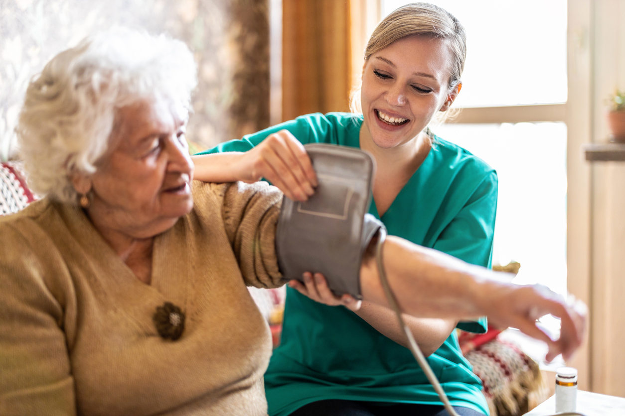 Female caretaker measuring senior woman's blood pressure at home Female caretaker measuring senior woman's blood pressure at home
