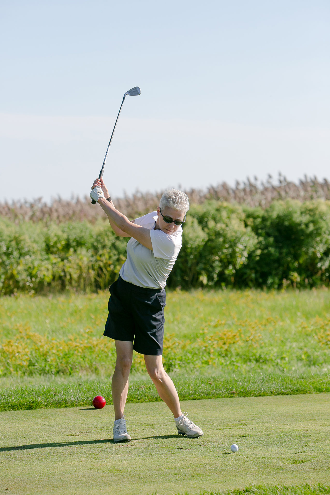 Woman prepares to hit golf ball with club