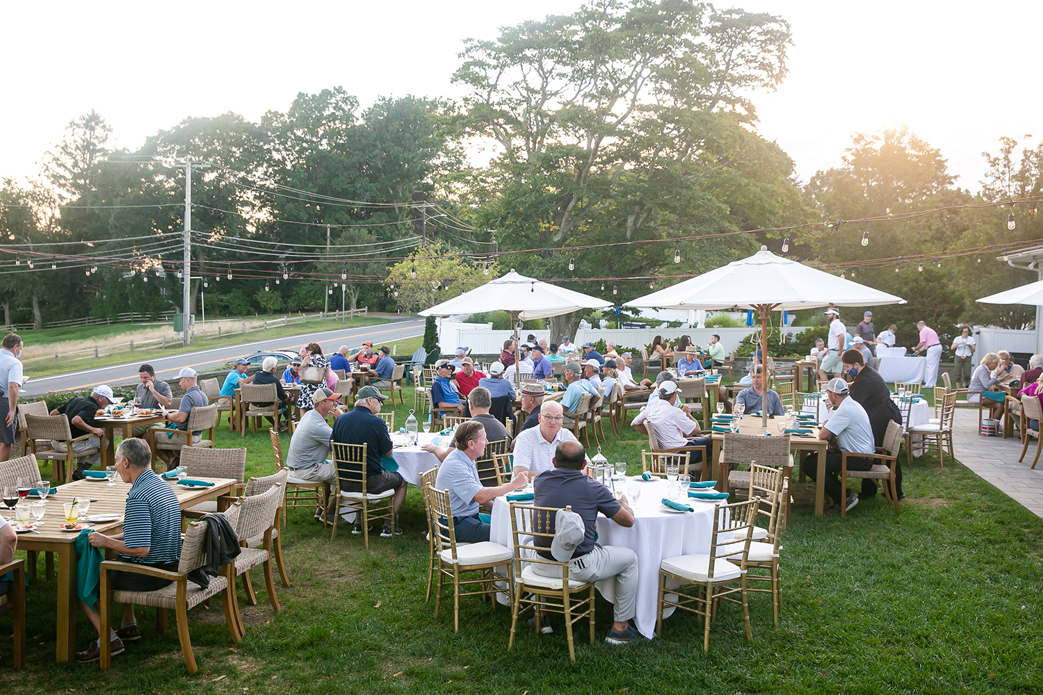 Donors sit at tables at suset