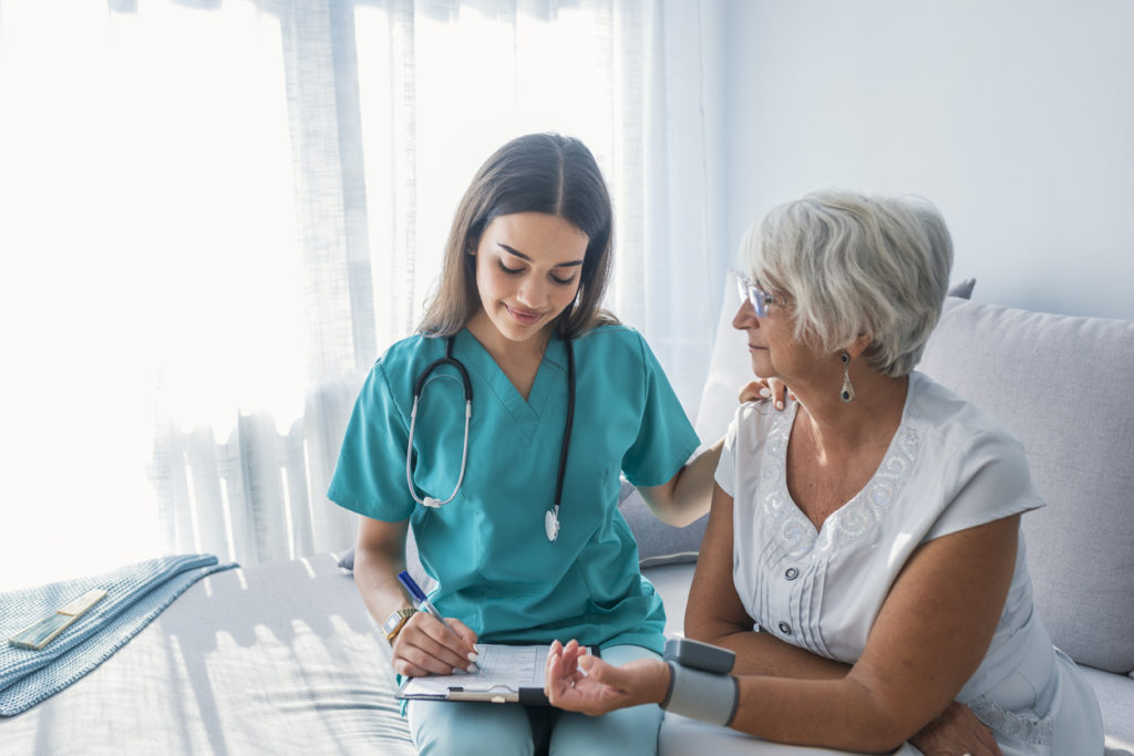 Massachusetts home care nurse measuring blood pressure of senior woman at home