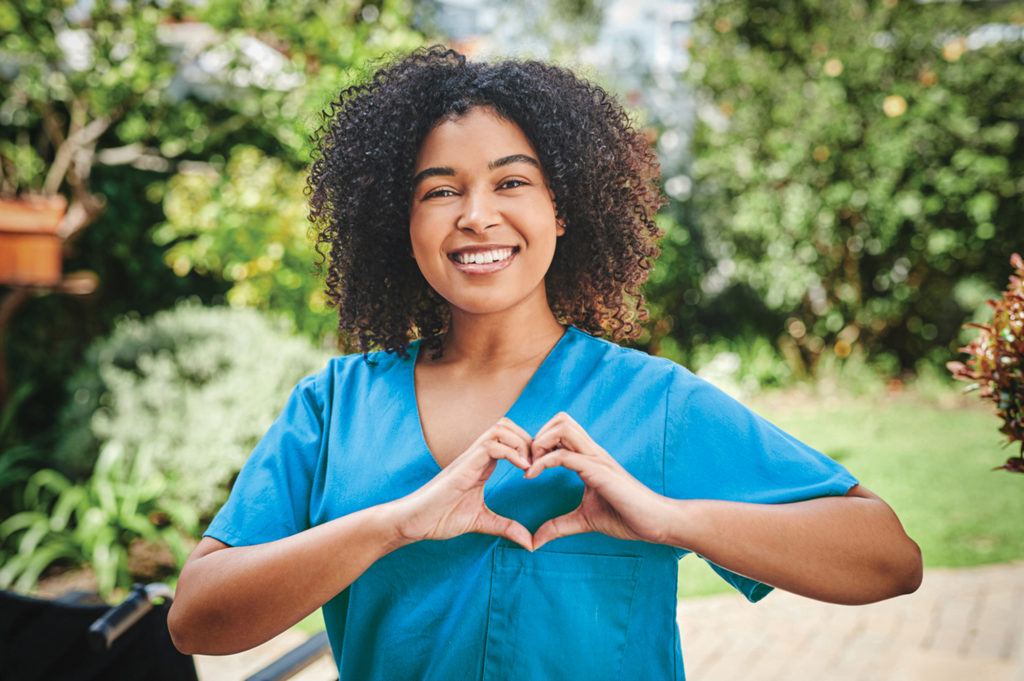 Female nurse holding her hands in the shape of a heart