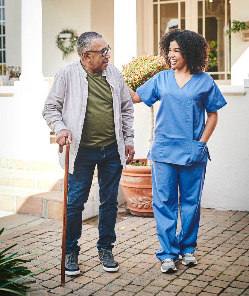 Female nurse walking male patient outside his home