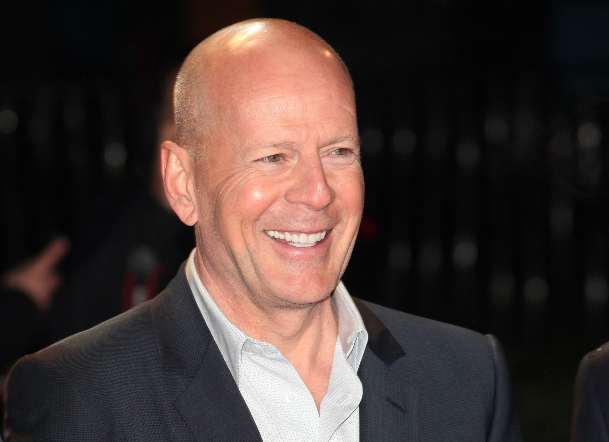 Bruce Willis, smiling in a suit
