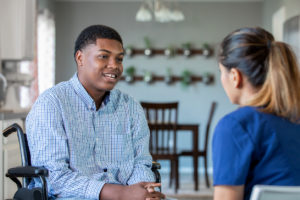 Home healthcare nurse with disabled teenage boy