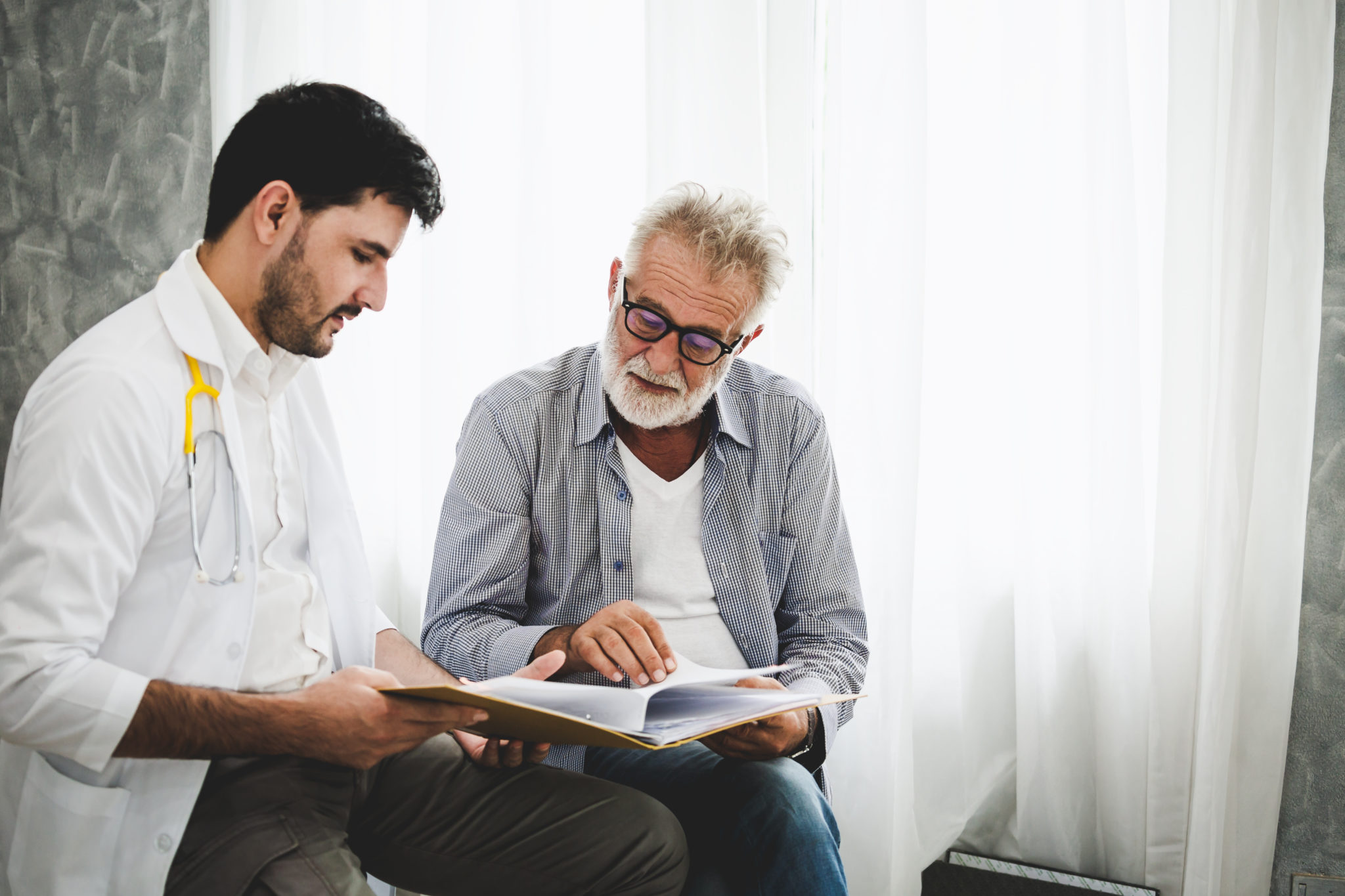 Elderly man looking at photos with his clinician for speech therapy