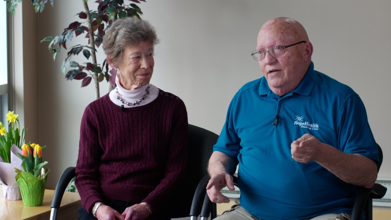 A man and woman sit together while talking about their dementia caregiver support group experience
