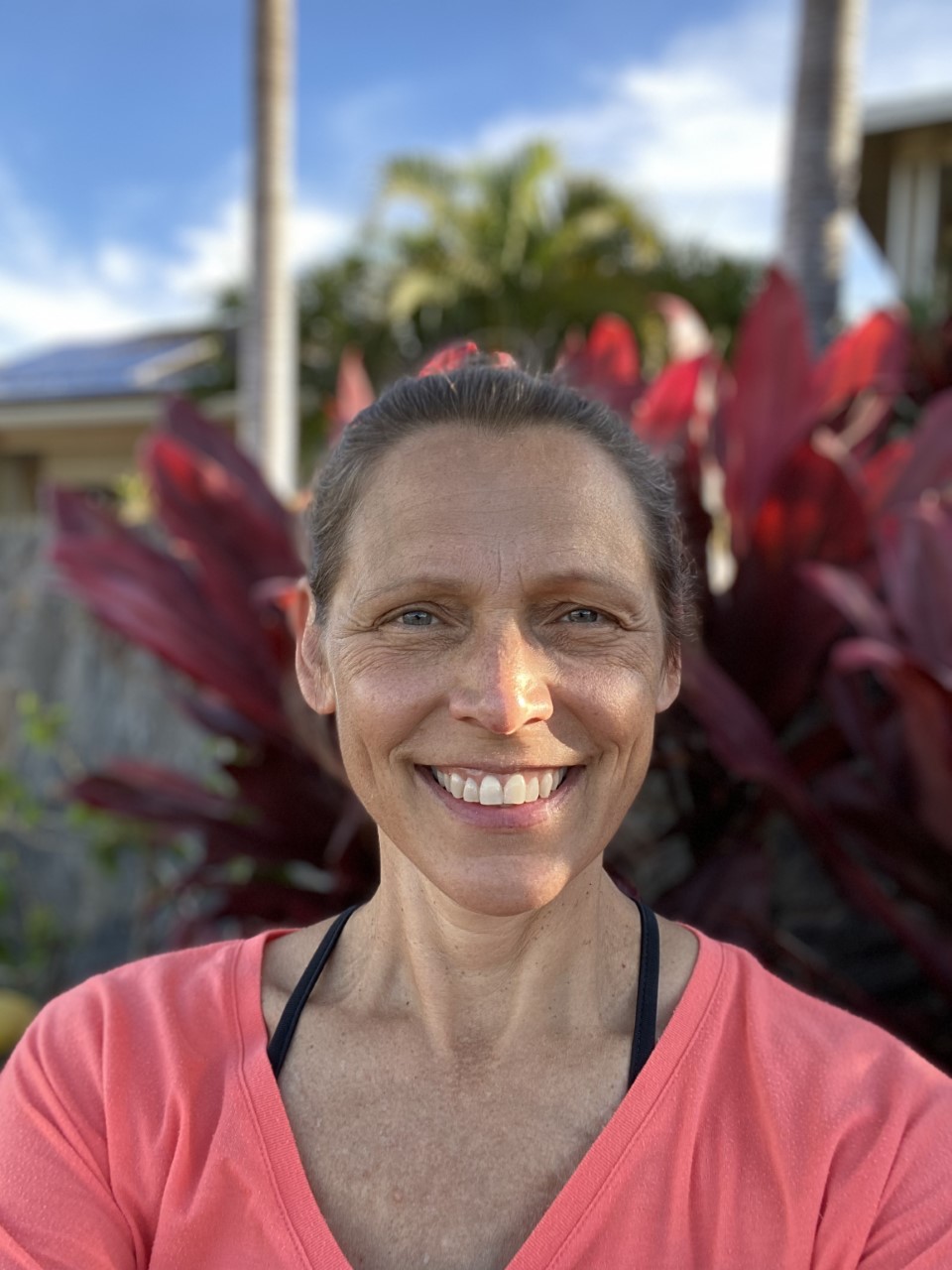 Woman smiling in front of a large plant