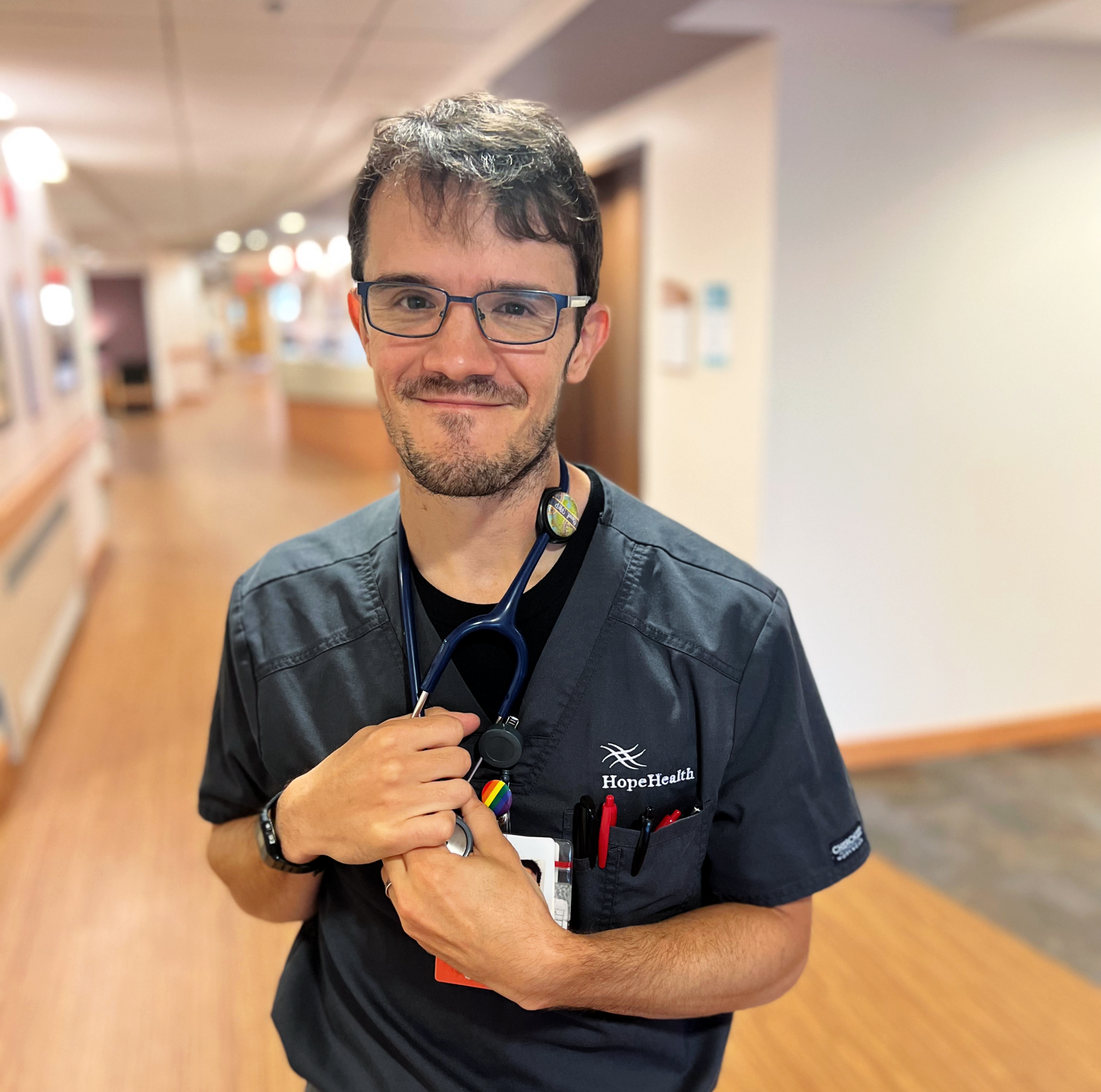 Male nurse standing in the halls of the HopeHealth Hulitar Hospice Center