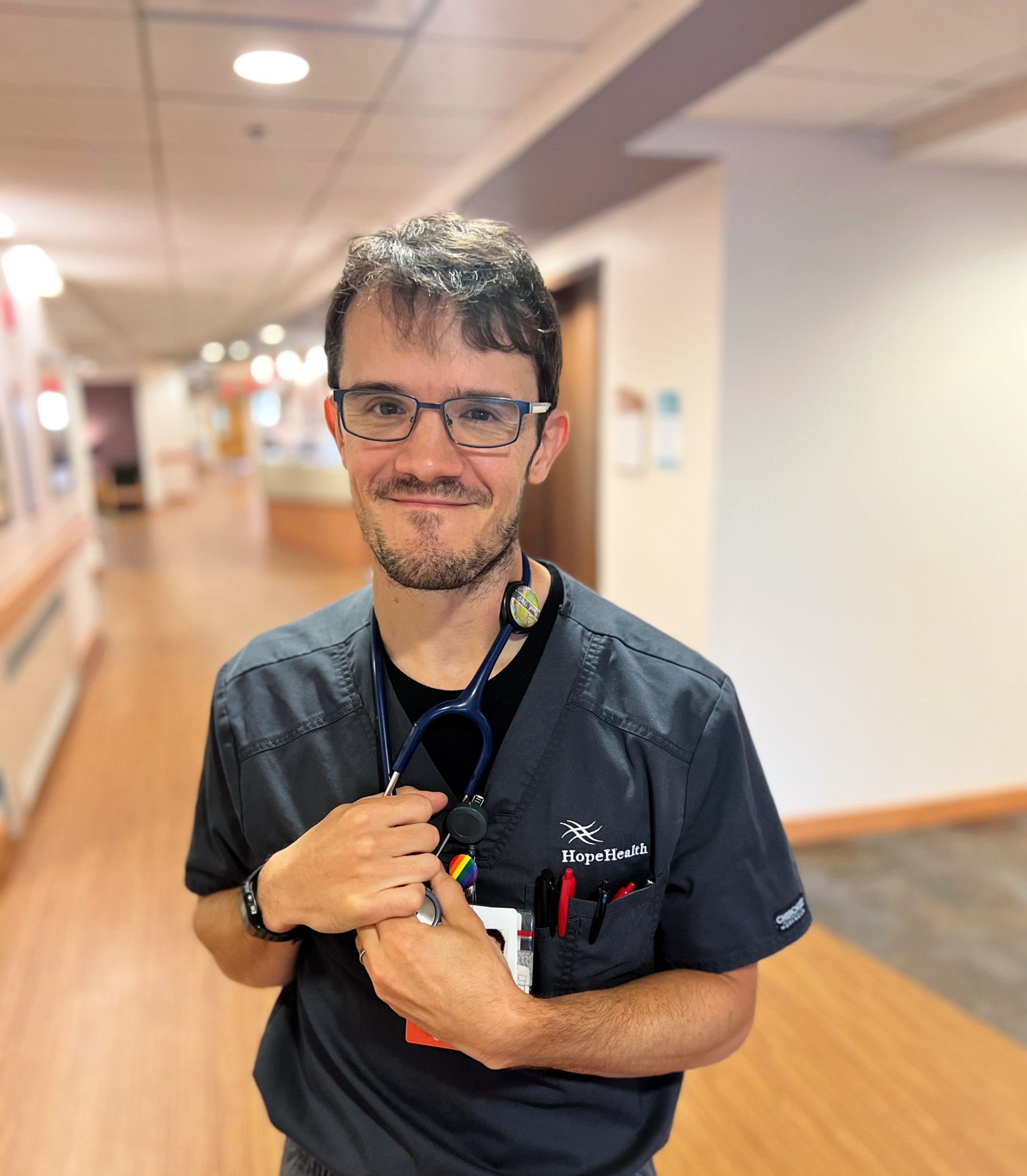 Male nurse standing in the halls of the HopeHealth Hulitar Hospice Center