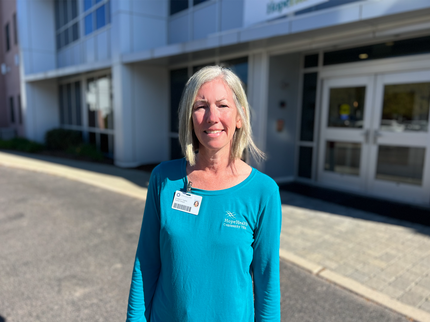 Physical therapist standing in front of an office building