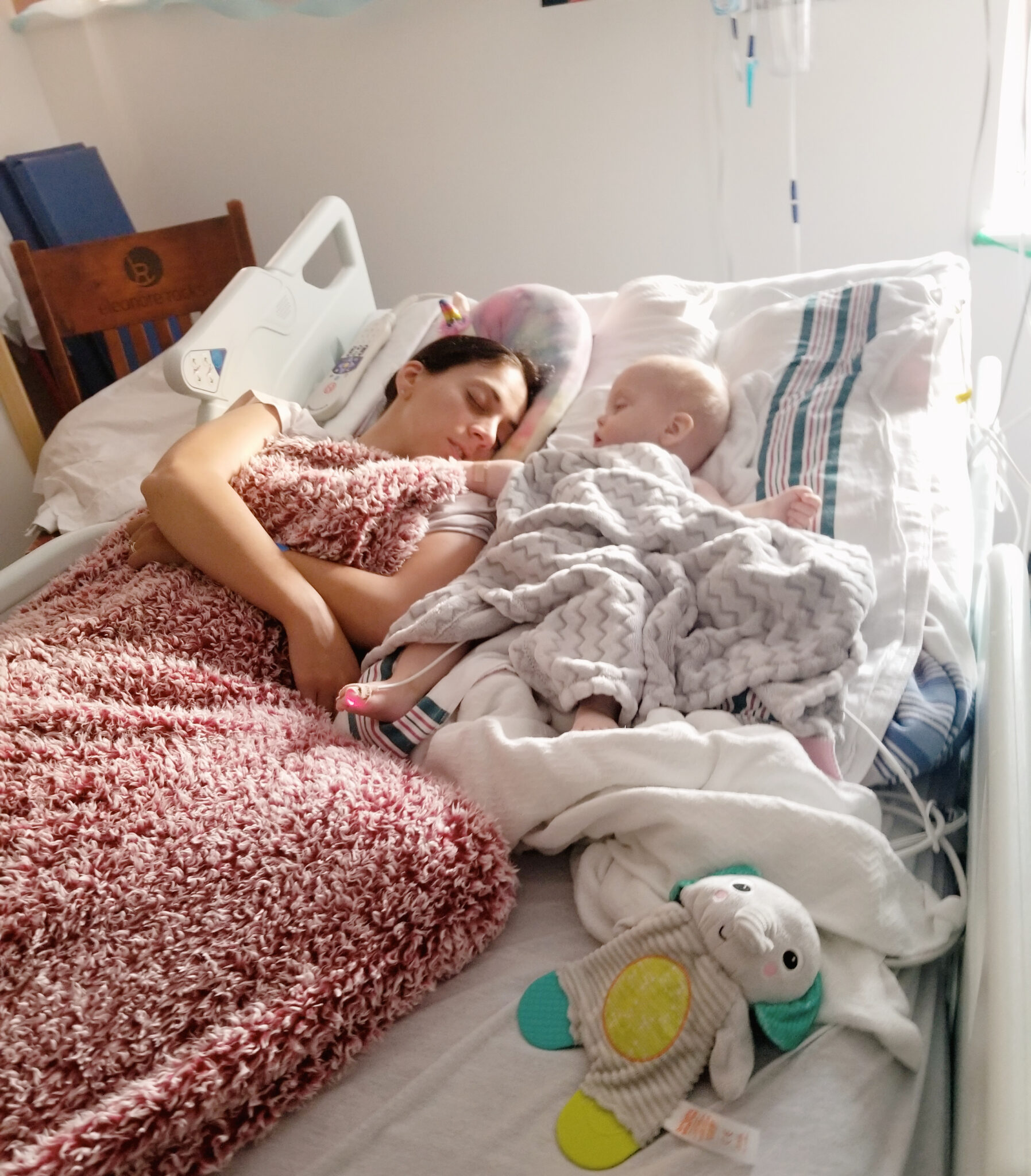 Mom laying with her infant son in hospital bed
