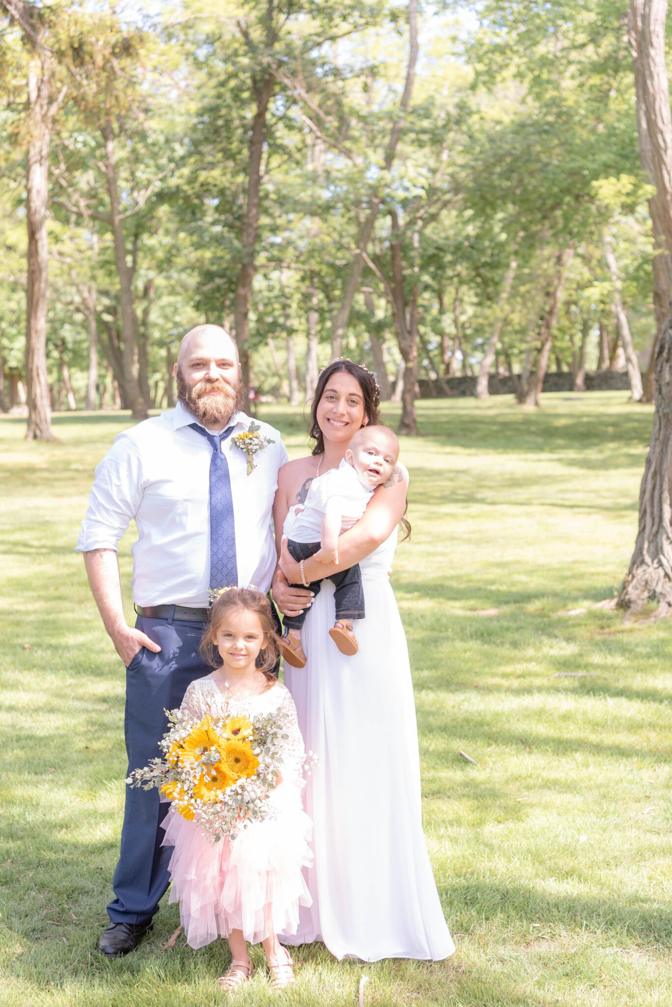 Mom and dad posing in the picturesque woods with their boy and girl